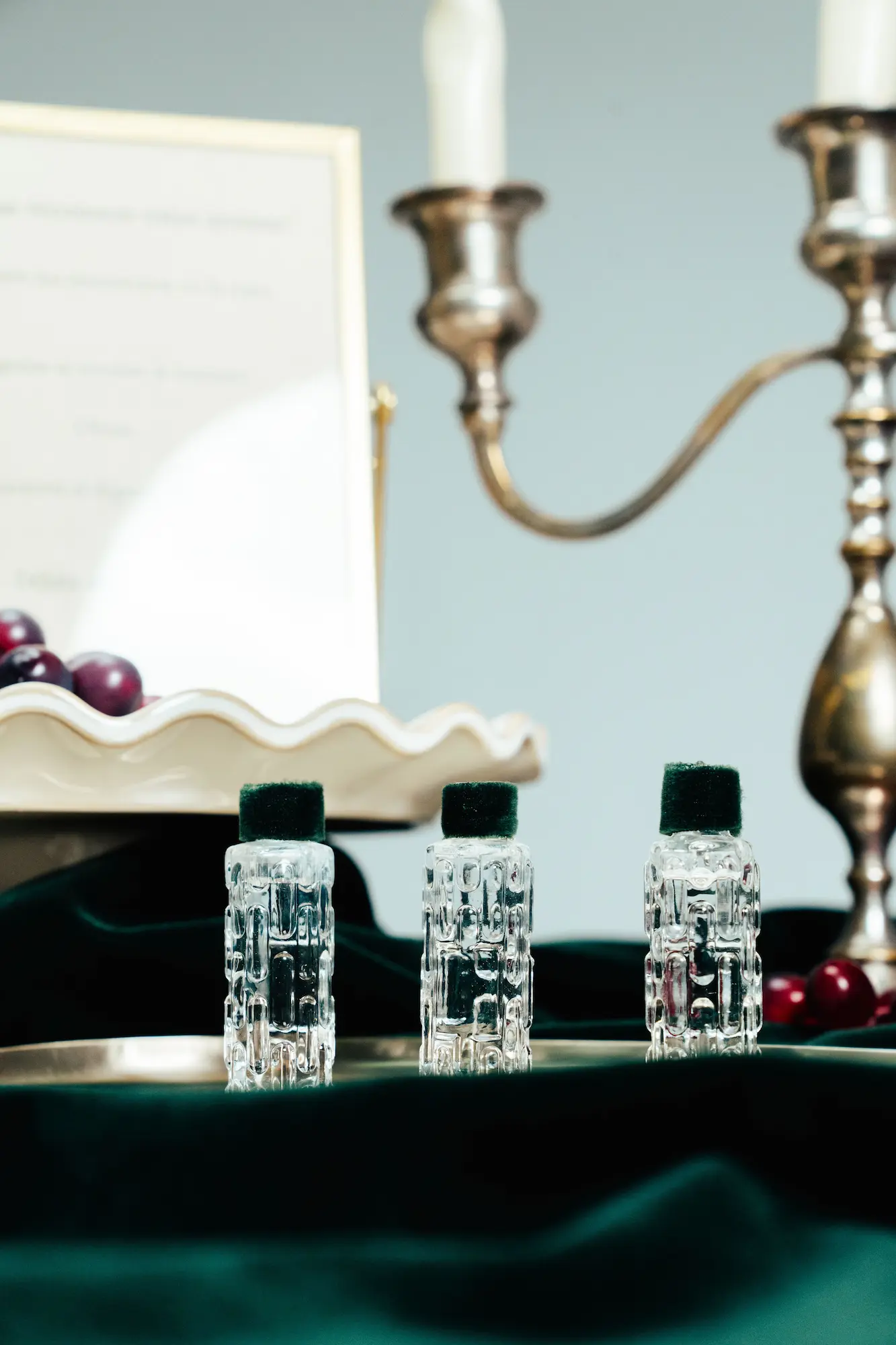 Tastu Drinks - Estaciones de Vino y Sidra Candelabro negro con velas blancas junto a un catálogo de vinos abierto sobre una mesa de madera.